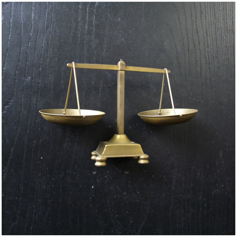 A brass balance scale, weighing software against human judgement
