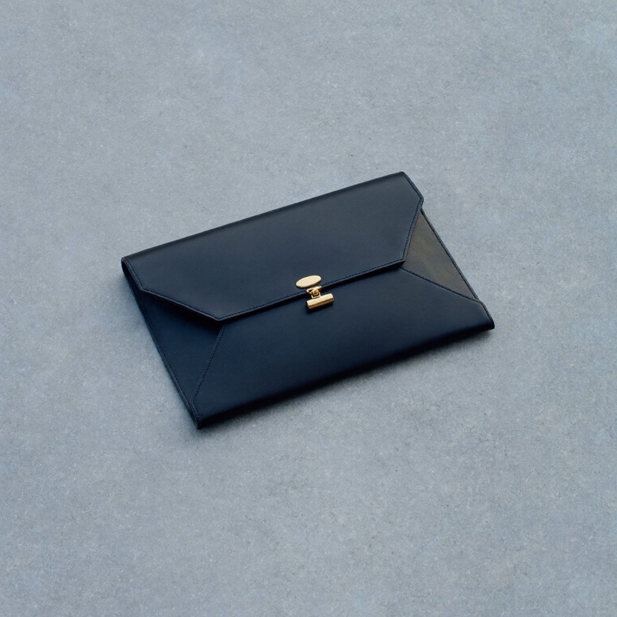 A closed black leather portfolio case, the kind a compensation package arrives in before anyone has read the small print