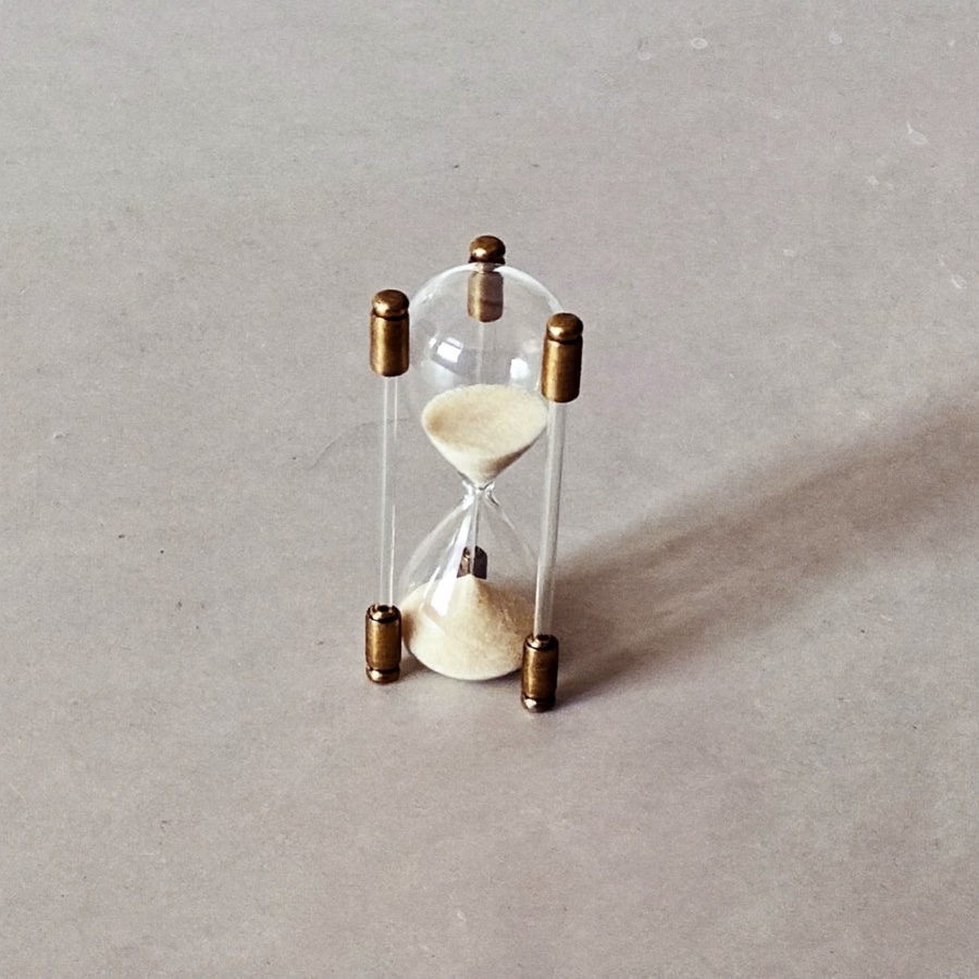A small hourglass on grey stone, for an article on short term career goals